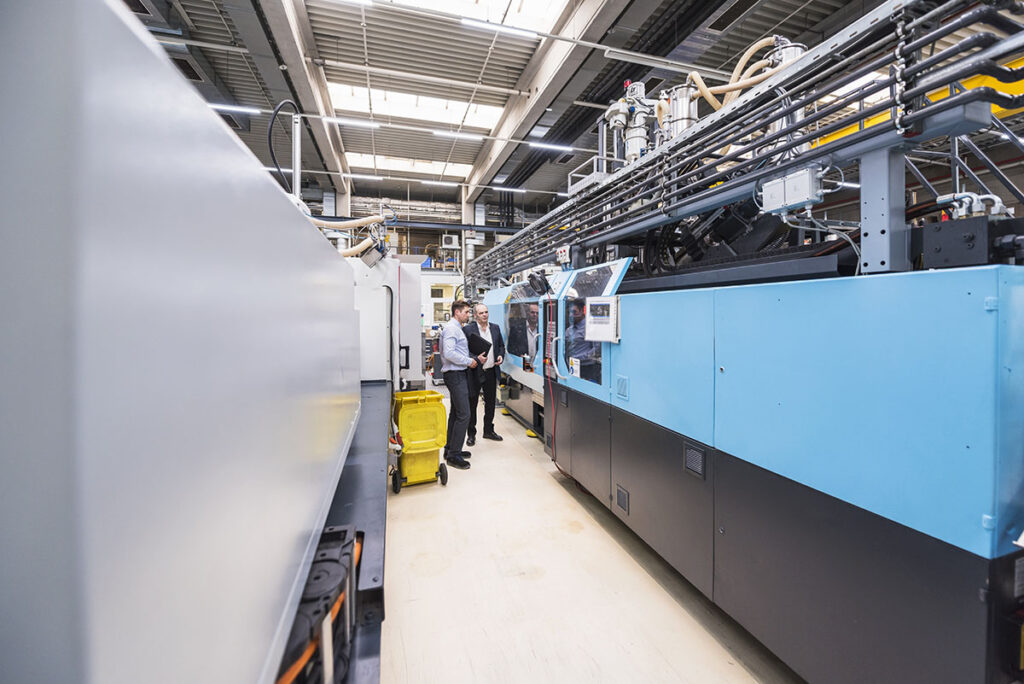 Two Men Talking About Machines In Factory Shop Floor